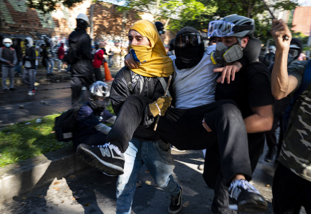 Stop motion picture of demonstrators carrying another injured demonstrator at a protest in Colombia. The picture was taken by Blackburn alumni