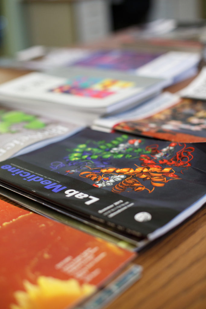 Close-up shot of scientific magazines laying at a table.