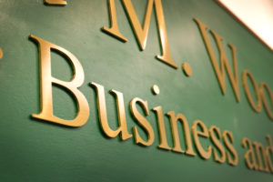 Close-up shot of the sign at the entrance to Woodson Hall. The shot is focused on the word "Business" on the sign.