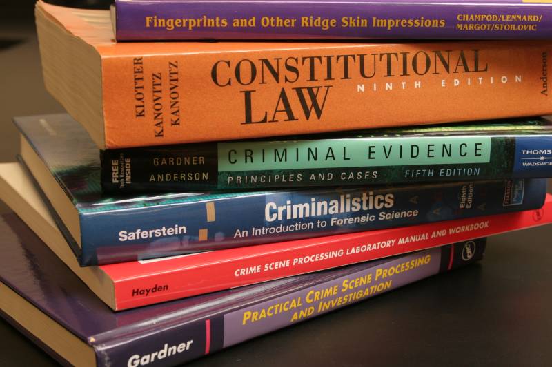 A stack of Criminal Justice books lying on top of a table.