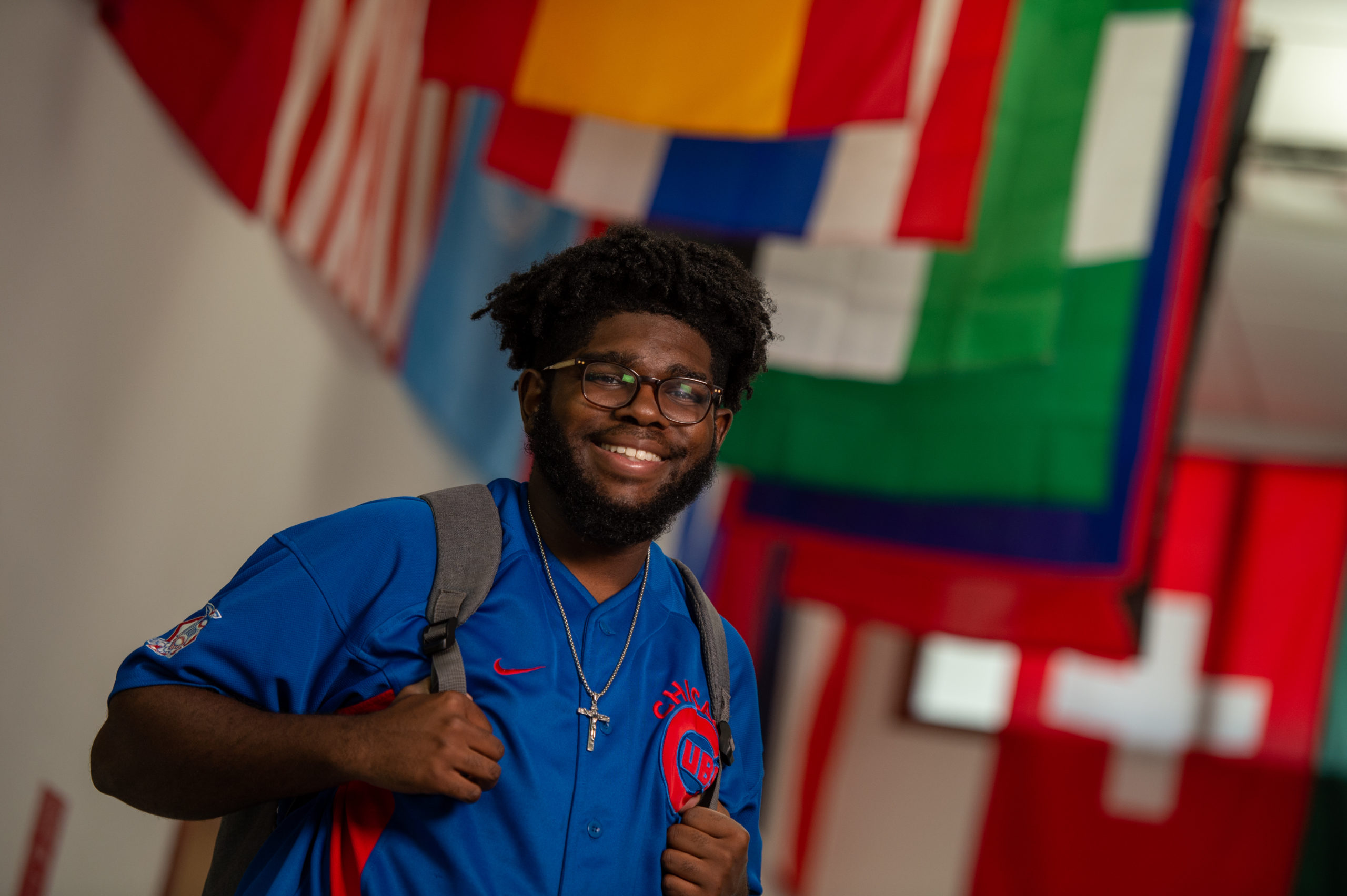 Blackburn student, Kionte Baker, posing for a picture near the flags at the Demuzio Campus Center.