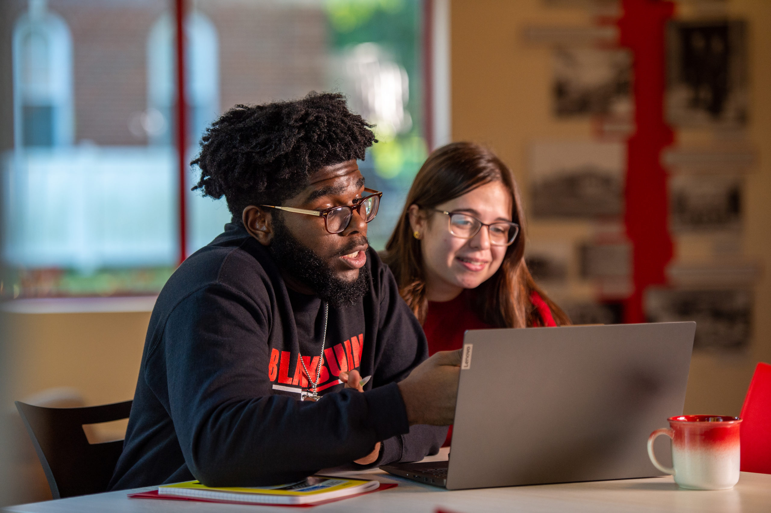 Two students sitting together and reviewing the contents of a laptop at the Jaenke Alumni Center.