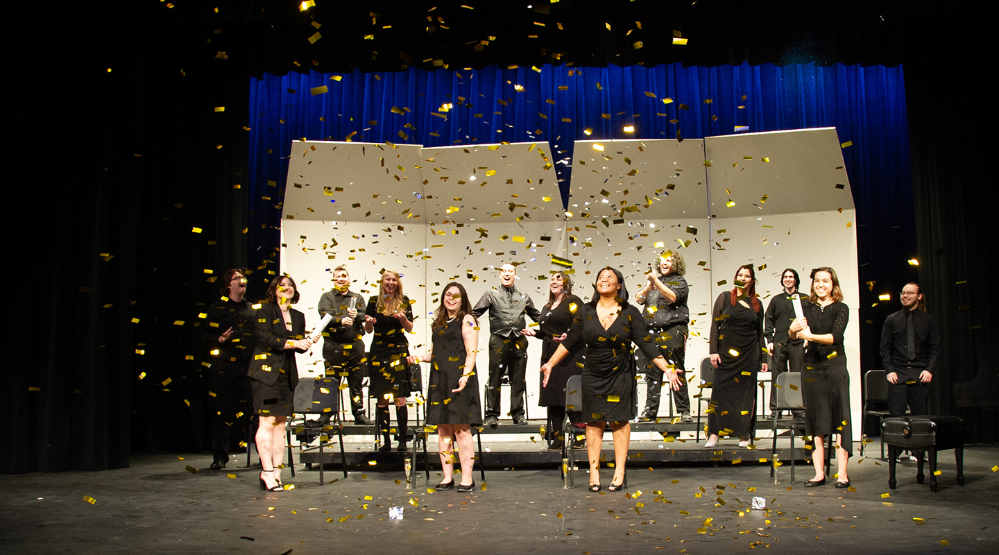 Blackburn Choir students performing at the Bothwell Auditorium as golden confetti sprinkles from above the stage.