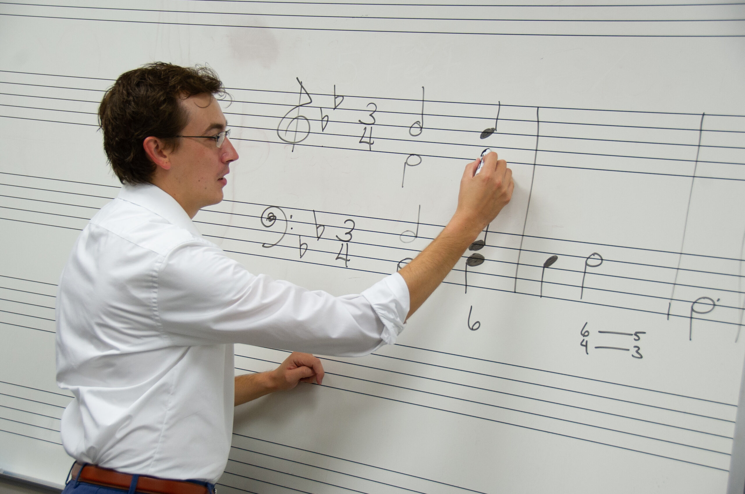 Blackburn's Music professor, Joseph Welch. drawing musical notes on a whiteboard.