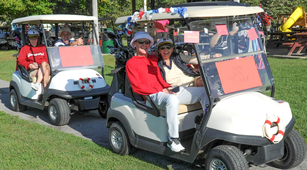 Blackburn alumni in golf carts during a Homecoming B-Club Golf Outing