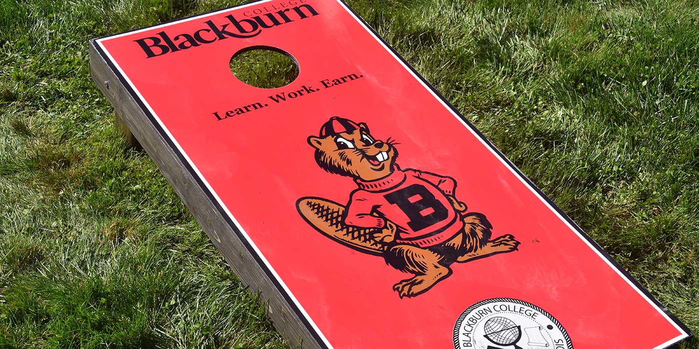cornhole board with Blackburn College logo, Barney the Beaver mascot and institutional commercial seal