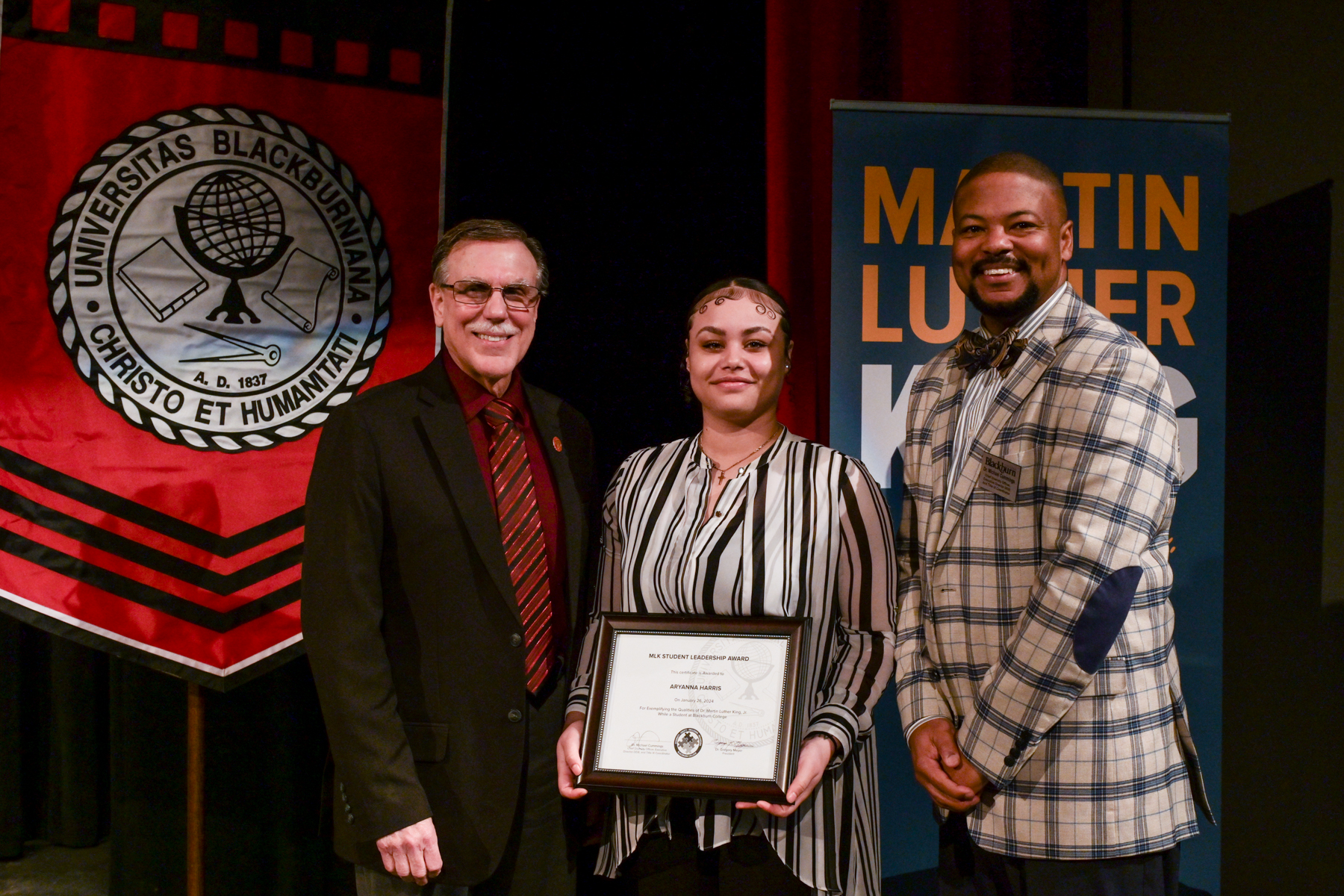Senior Aryanna Harris (center) pictured with Blackburn College President Gregory J. Meyer (left) and Chief Diversity Officer and Executive Director of Diversity, Equity, Inclusion and Belonging Dr. Michael Cummings (right) on stage following the annual MLK Convocation at Blackburn College.