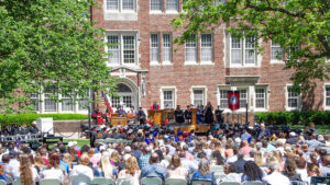 Photo of a giant crowd, Blackburn graduates seated and a full stage of administrators and guests during Blackburn College's 155th Commencement for the Class of 2024