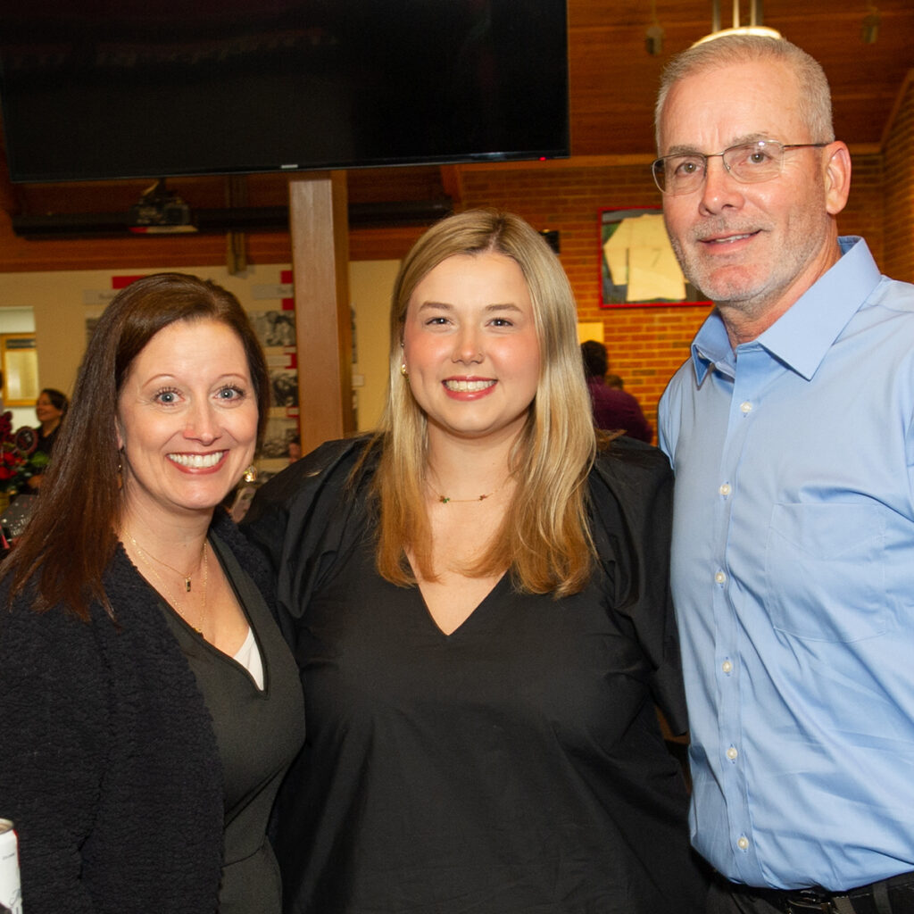 Claire Stein, Class of 2024 speaker at Senior Convocation, photographed surrounded by her parents during the Senior Send-Off event