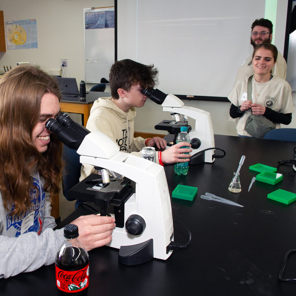 Students looking through microscope during 2024 Science Day