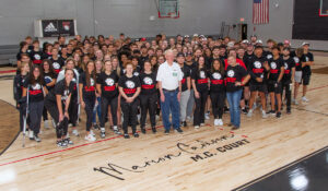 Alumnus Paul James '67 was photographed with student-athletes near Marion Carlson's signature. James was influential in this project, which honored MC and her legacy at Blackburn.