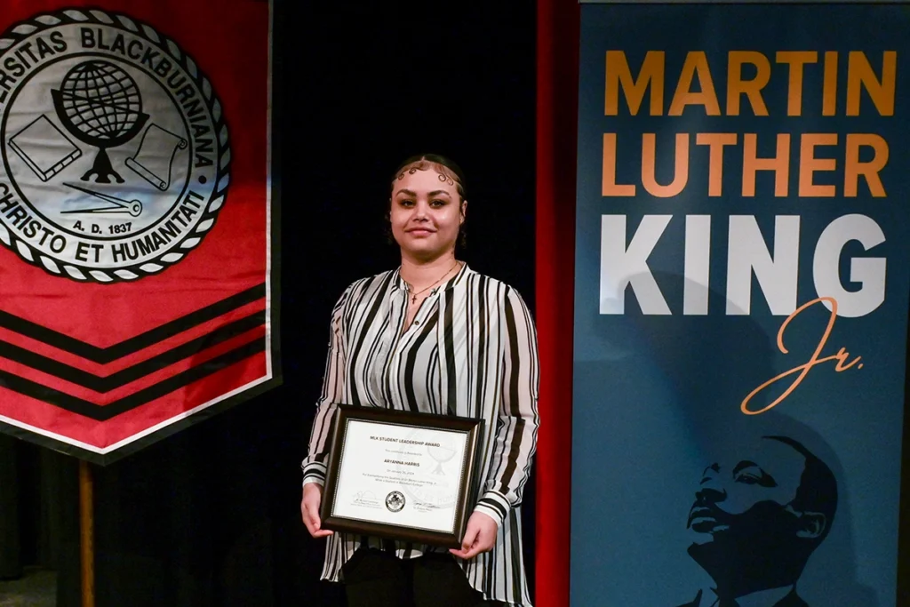 Aryanna Harris '24 holds MLK Student Leadership Award on Bothwell Auditorium stage