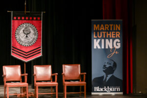 Bothwell Auditorium stage with three chairs, the Blackburn College seal banner and a banner with Dr. Martin Luther King, Jr.