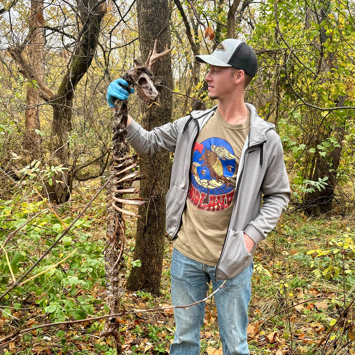 student on biology field study holding up discovered skeleton