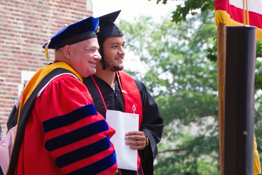 President Larry K. Lee hands student diploma on stage