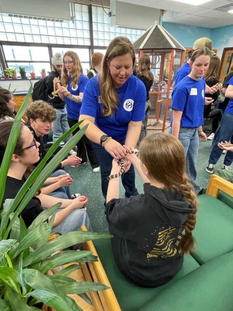 Students hold a snake while visiting the Blackburn Vivarium