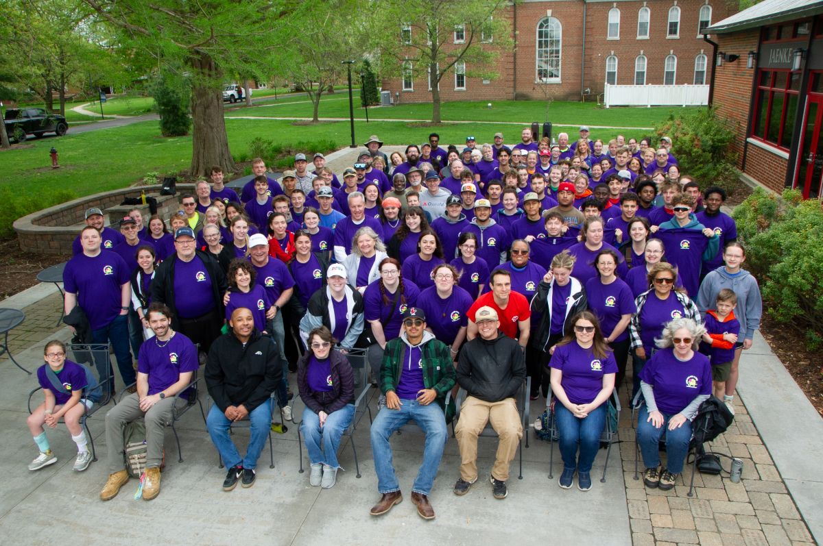 Large group of alumni, current students, faculty and staff gather on Jaenke Patio at the start of Beautification Day