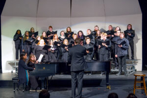 Blackburn Choir performs on risers behind grand piano