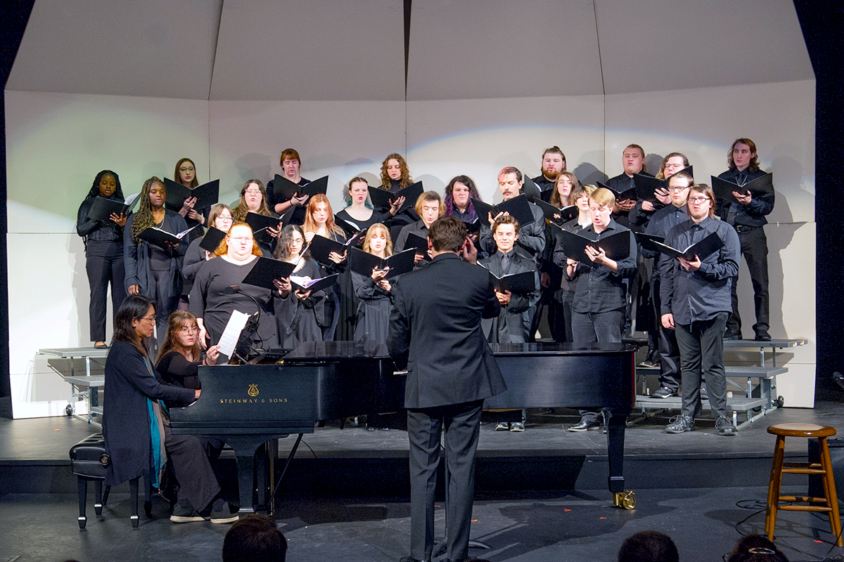 Blackburn Choir performs on risers behind grand piano