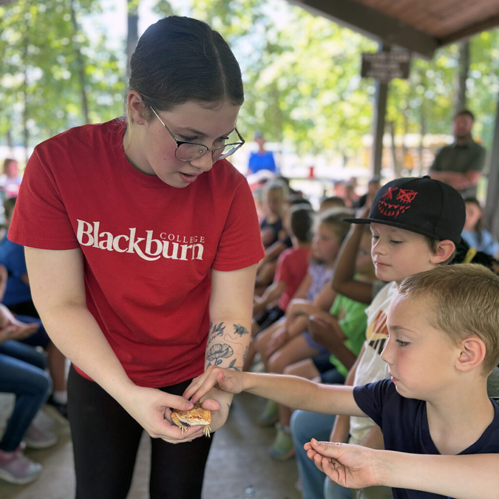 Blackburn student holds animal for as second grade students safely touch