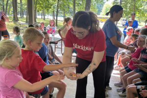 Blackburn student holds animal for as second grade students safely touch