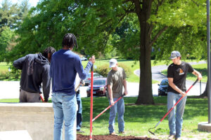 Blackburn student workers spreading mulch outside Dawes Woodward