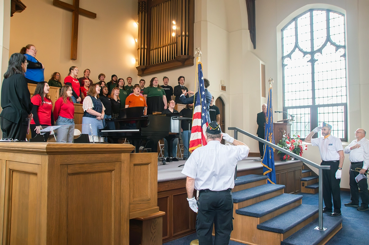 Veterans salute flag in Clegg Chapel at 2025 Veterans Day Convocation